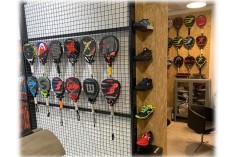 Support pour raquettes de padel sur grille métallique avec détail agrandi du crochet d’exposition. 2