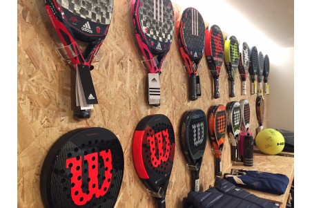 Expositor de pared con palas de pádel instalado con Pack Pared que Vende, exposición ordenada para tienda de pádel