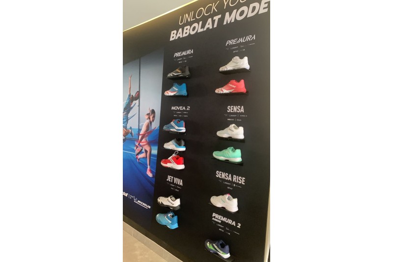Mur commercial équipé d’étagères modulaires Shelf2000 pour présenter des chaussures de sport dans un showroom professionnel